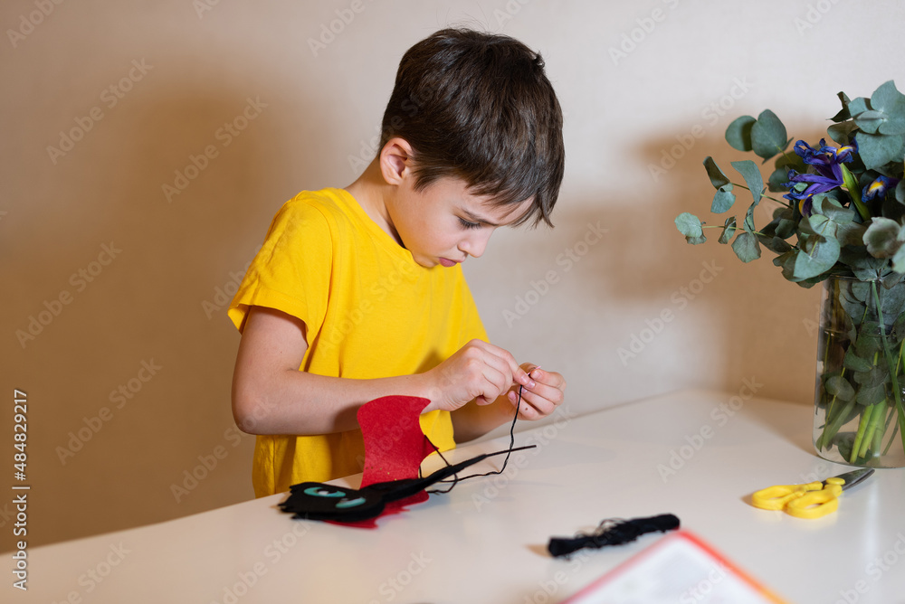 the boy is doing needlework. Sewing a soft toy from felt, hands close-up. Pastime at home. the boy is doing needlework. Sewing a soft toy from felt, hands close-up. Pastime at home.