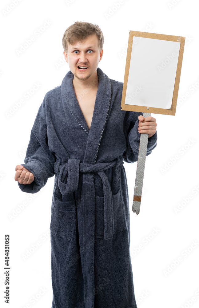 a man in a gray terry dressing gown with anger looks aggressively at us. the guy clenched his fist and holds the banner. place for an inscription. protest, riot. isolated, white background. a man in a gray terry dressing gown with anger looks aggressively at us. the guy clenched his fist and holds the banner. place for an inscription. protest, riot. isolated, white background.