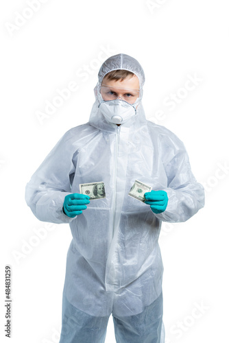 a scientist in special protective clothing holds a torn bill  dollars and looks seriously at us. Bacteria  viruses  toxic  caustic substances  coronavirus epidemic  flu. isolated