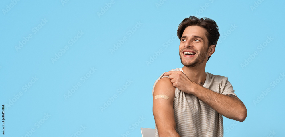 Man Showing Arm With Sticking Plaster After Vaccine Injection And Looking Away Man Showing Arm With Sticking Plaster After Vaccine Injection And Looking Away