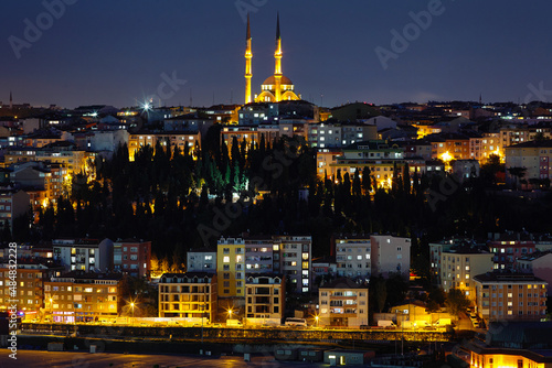 Night view of the illuminated city, the illuminated houses and the mosque. Lights are on in the windows. Journey to istanbul