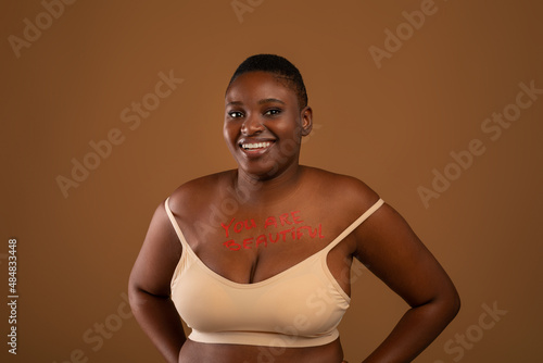 Curvy Smiling Black Woman Posing With Inscription On Her Chest photo