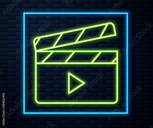 Glowing neon line Movie clapper icon isolated on brick wall background. Film clapper board. Clapperboard sign. Cinema production or media industry. Vector