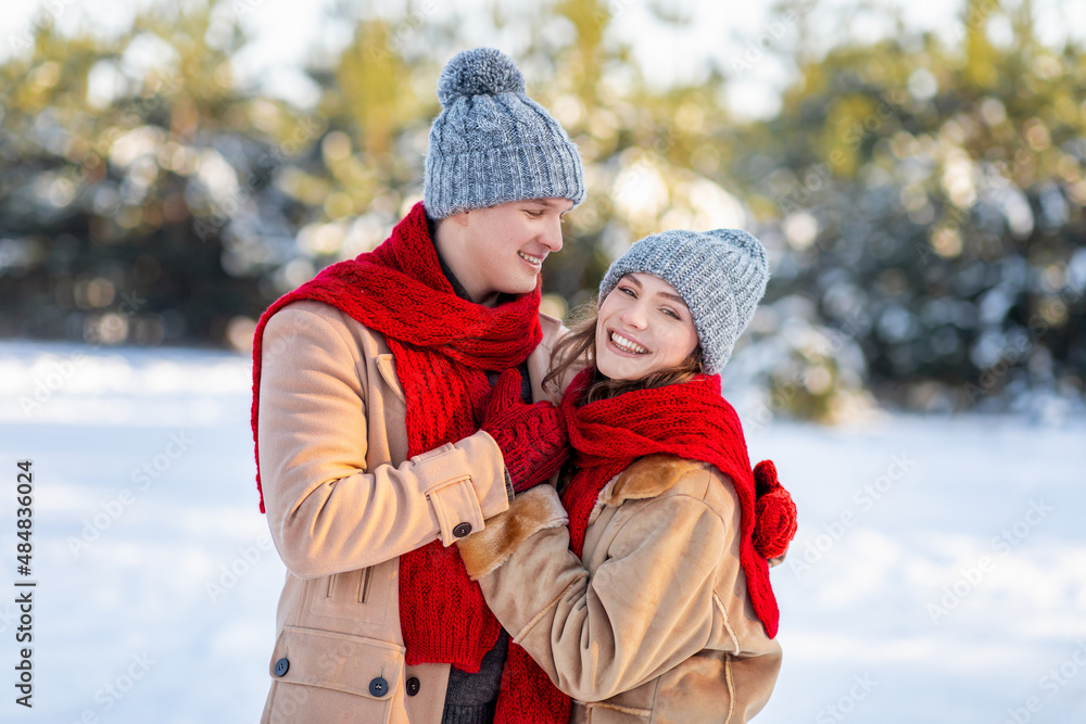 Loving man and woman enjoying weekend at winter forest