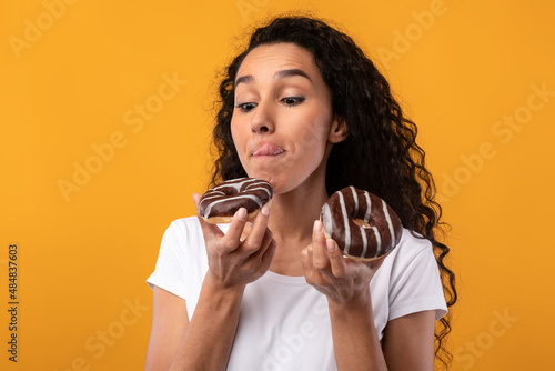 Happy Latin Lady Holding Doughnuts At Studio photo
