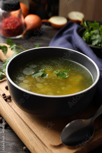 Concept of tasty food with chicken soup or broth on wooden table