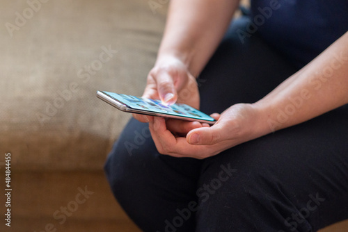 Woman holding, using smart phone and reading phone message. Hands holding mobile phone and typing