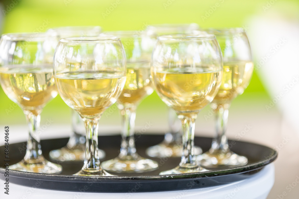 Full glasses with white wine on a tray