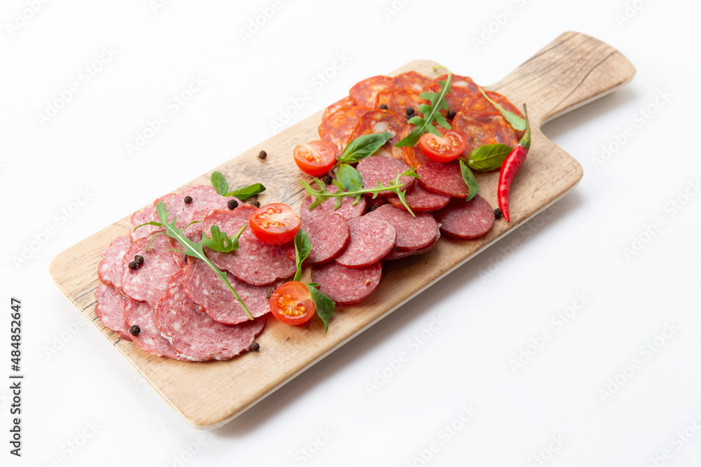 Various meat snacks on the board. On white background. Various meat snacks on the board. On white background.