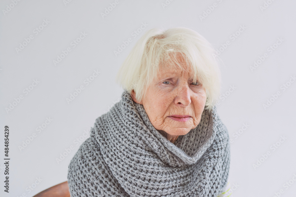 senior ill woman in scarf freezing cold at home. Health care, crisis, oldness concept senior ill woman in scarf freezing cold at home. Health care, crisis, oldness concept