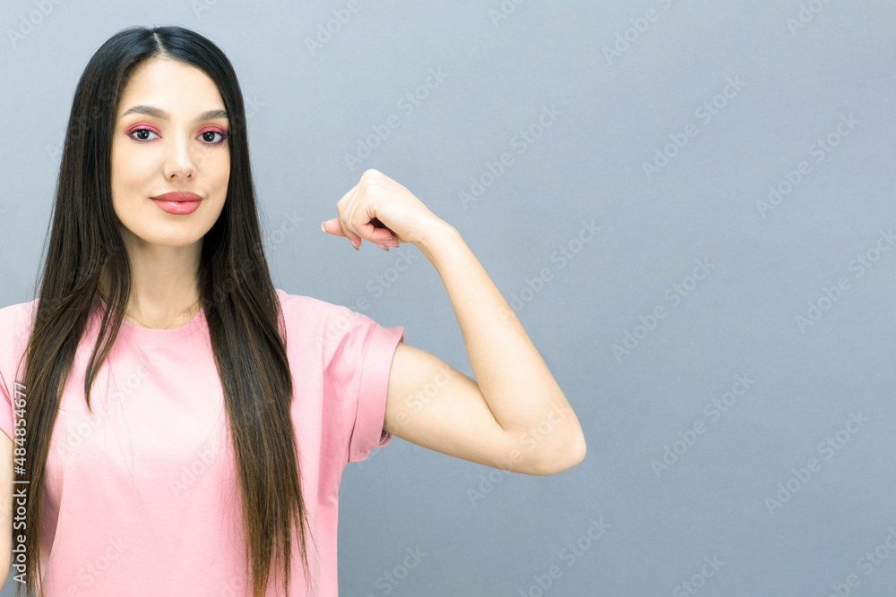 Crazy strong young woman, bicep muscles isolated on gray background studio Crazy strong young woman, bicep muscles isolated on gray background studio