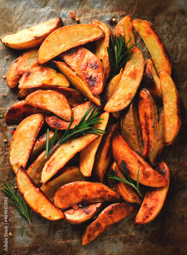 Foto Fried potato slices , homemade , on parchment,burned , top view, close-up,