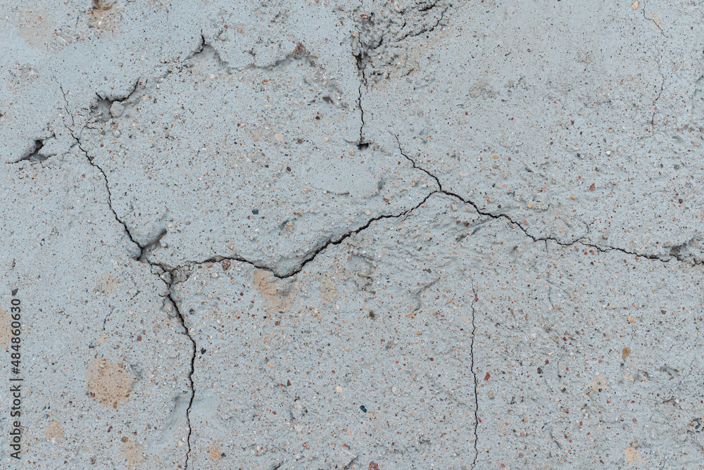Fototapeta premium Cracked concrete wall gray cement surface background.cracked grey stone wall in winter.close-up.