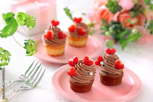 Chocolate cupcakes with chocolate cream with strawberry heart. Valentine bouquet of rose flowers and gift. チョコレートカップケーキ バレンタイン バレンタインデー