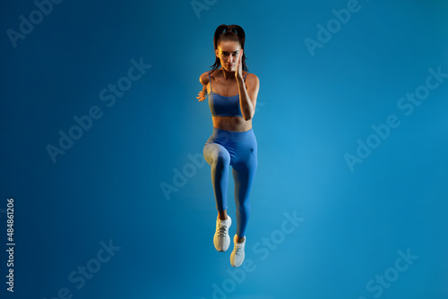 Wallpaper Mural Front-View Of Motivated Sportswoman Running Over Blue Background, Full Length Torontodigital.ca