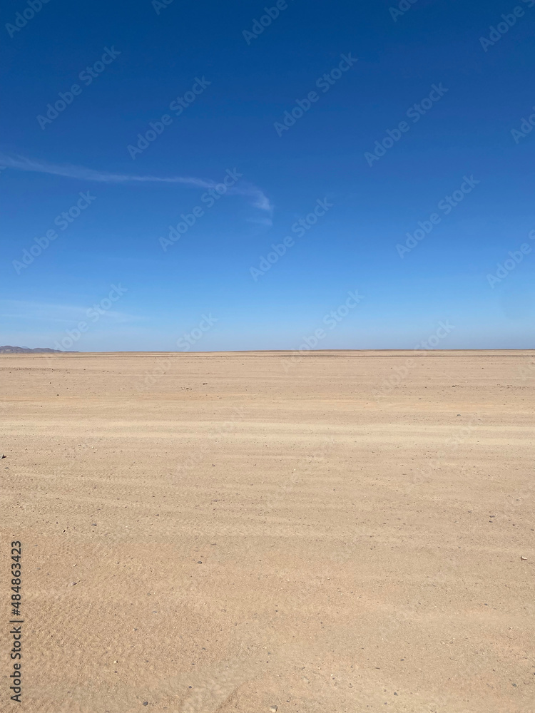 Desert landscape. Mountains on the horizon. Cloudless day. Walk in the desert.