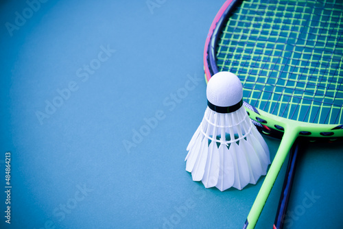 Cream white badminton shuttlecock and racket on floor in indoor badminton court, copy space, soft and selective focus on shuttlecocks. photo