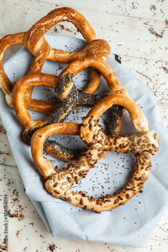 Fresh prepared homemade soft pretzels. Different types of baked bagels with seeds on a black background.