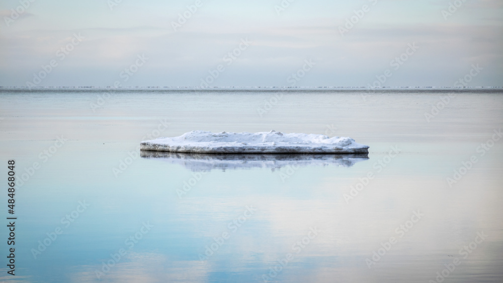 white pieces of ice floating in the sea, winter landscape from the sea, calm water, sky reflections in the sea white pieces of ice floating in the sea, winter landscape from the sea, calm water, sky reflections in the sea