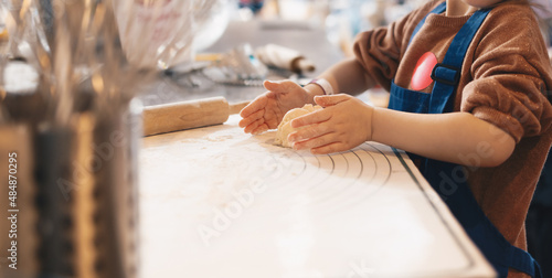 Cooking baking workshop class for school kids. Cute girl playful learning to bake cakes having fun. Kids playing with wheat flour and rolling pin