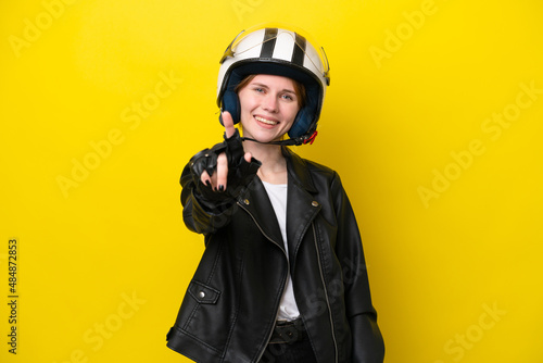 Young English woman with a motorcycle helmet isolated on yellow background showing and lifting a finger © luismolinero