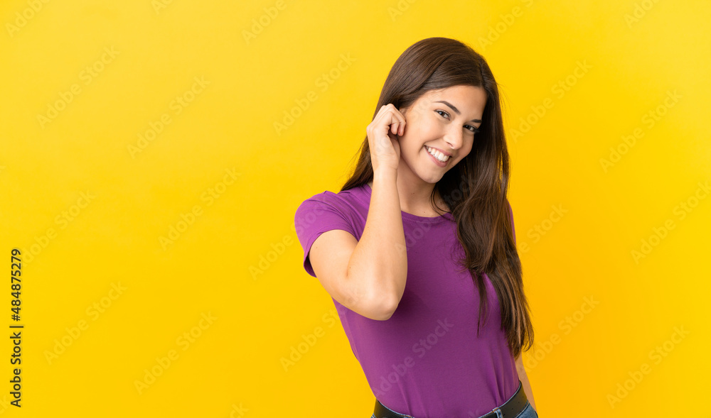 Teenager Brazilian girl over isolated yellow background laughing Teenager Brazilian girl over isolated yellow background laughing
