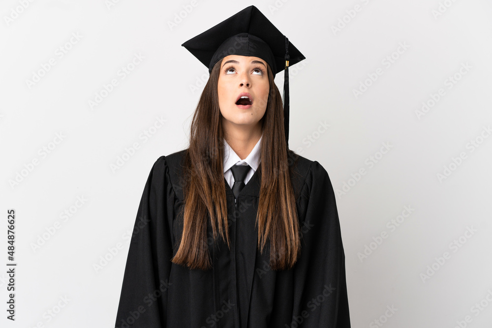 Teenager Brazilian university graduate over isolated white background looking up and with surprised expression Teenager Brazilian university graduate over isolated white background looking up and with surprised expression