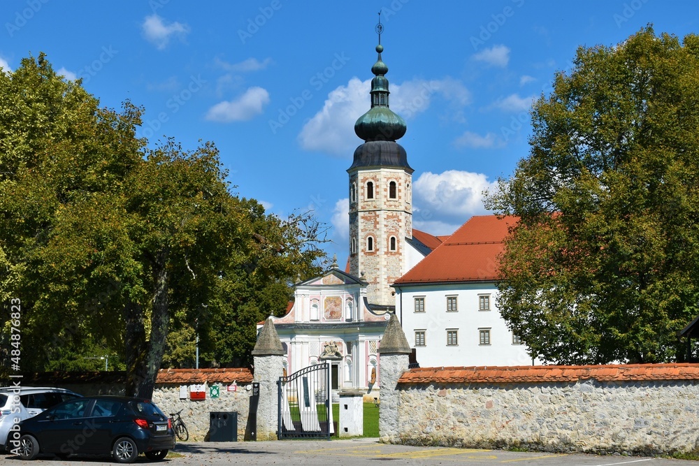 View of the entrance of ancient Cistercian monastery Kostanjevica or Kostanjevica castle in Dolenjska, Slovenia with trees and the old church tower View of the entrance of ancient Cistercian monastery Kostanjevica or Kostanjevica castle in Dolenjska, Slovenia with trees and the old church tower