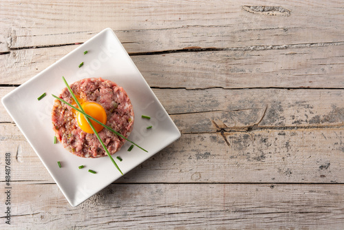 Foto Beef steak tartare on wooden table. Top view. Copy space