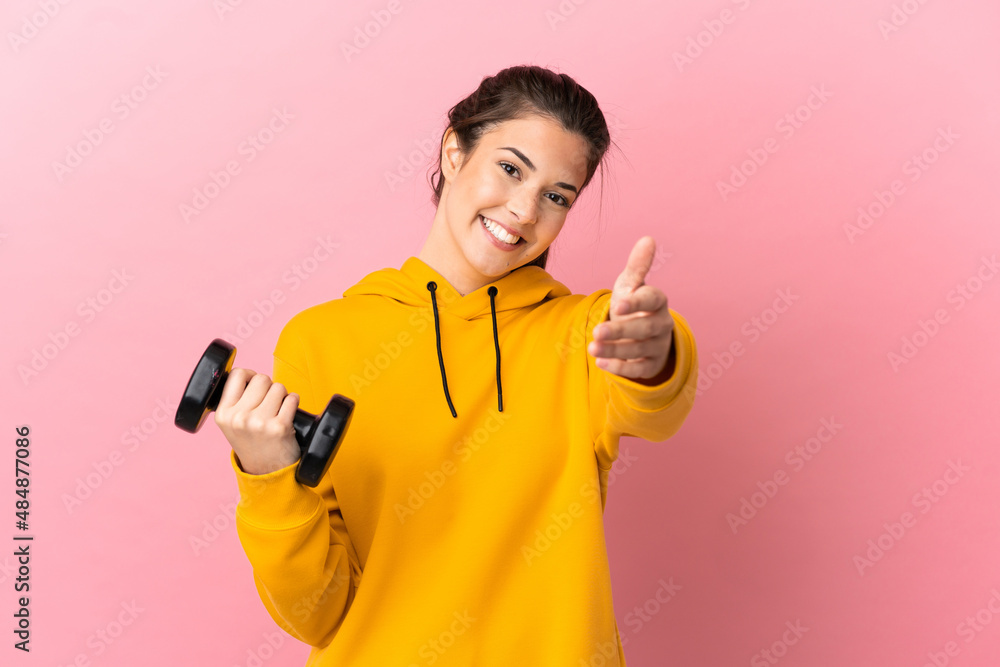 Young sport girl making weightlifting over isolated pink background shaking hands for closing a good deal Young sport girl making weightlifting over isolated pink background shaking hands for closing a good deal