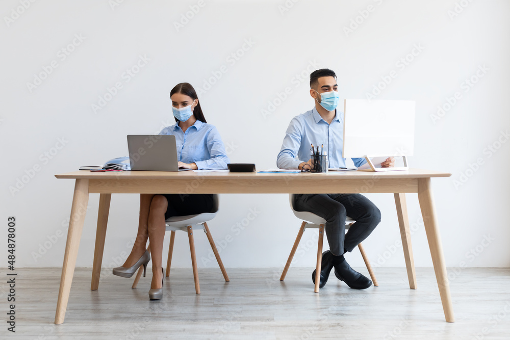 Colleagues in disposable face masks working on pc at office Colleagues in disposable face masks working on pc at office