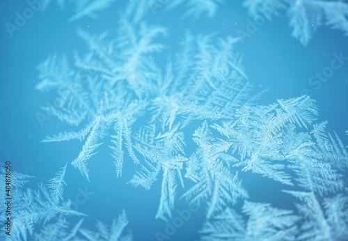 Abstract frosty pattern on glass  blue background texture.