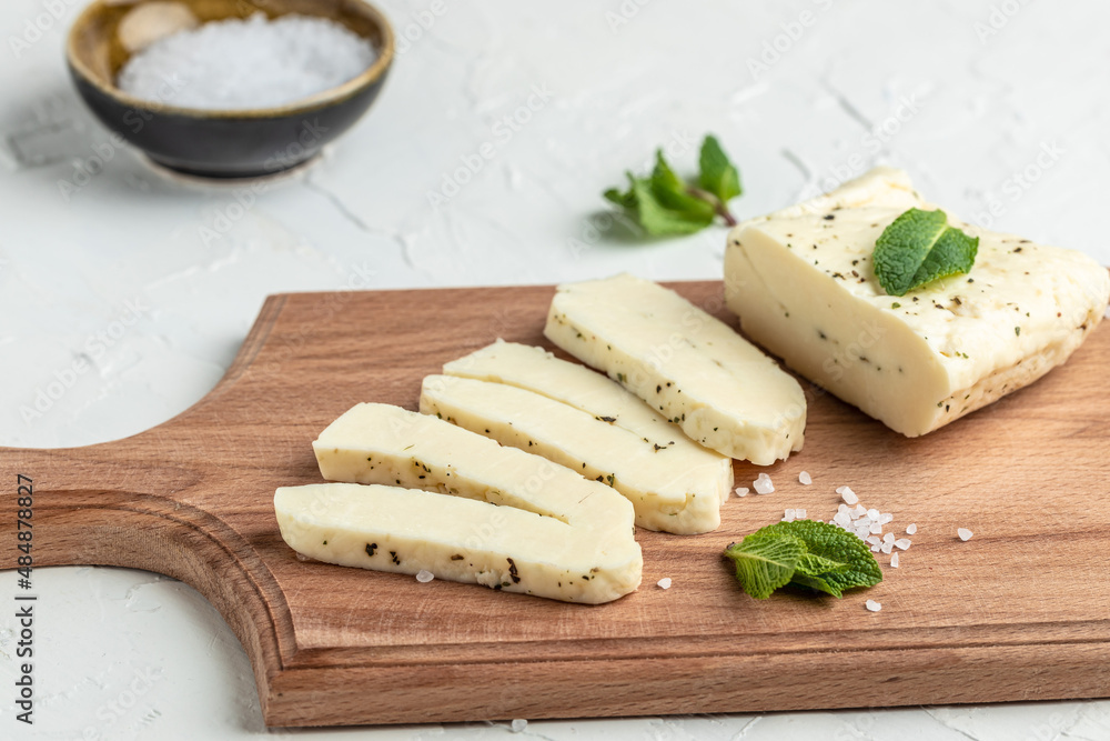 Piece of fresh sliced halloumi with mint. Cyprus squeaky cheese. banner, menu, recipe place for text, top view