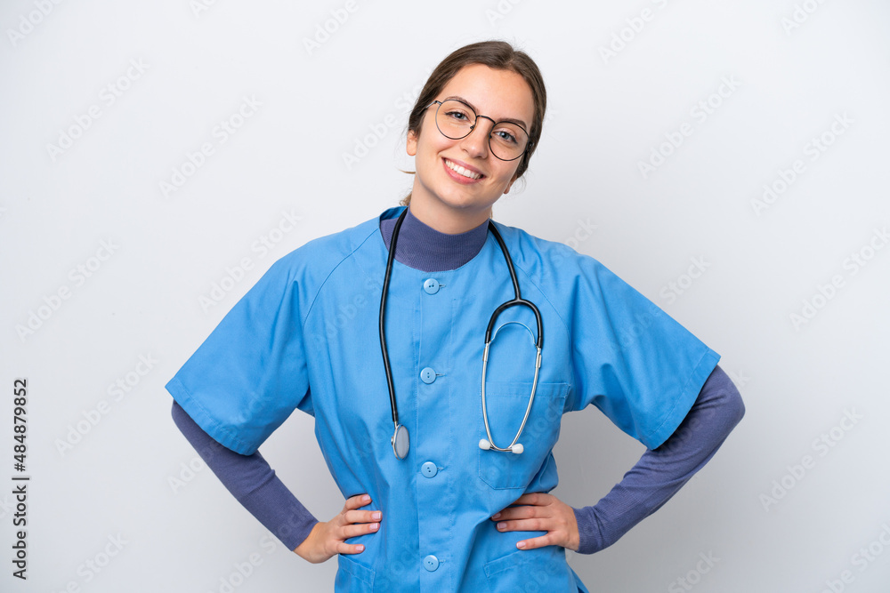 Young caucasian nurse woman isolated on white background posing with arms at hip and smiling Young caucasian nurse woman isolated on white background posing with arms at hip and smiling