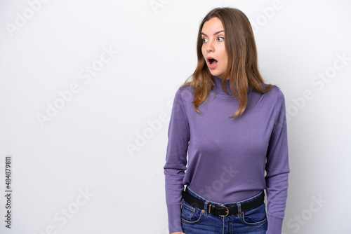 Young caucasian woman isolated on white background doing surprise gesture while looking to the side © luismolinero