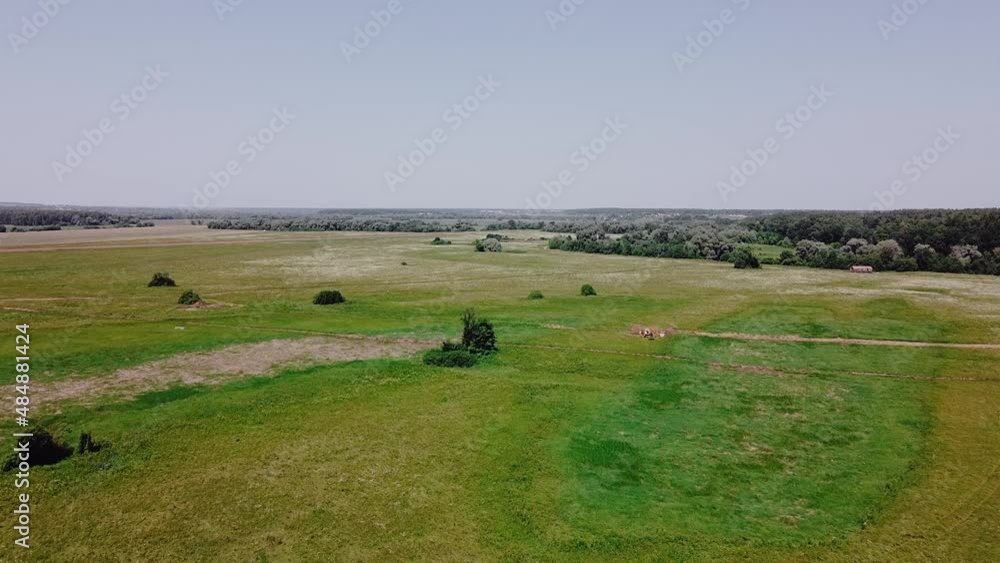 Aerial cinematic clip: A drone flies over a field on a warm summer day. A drone flies over a green forest. A beautiful summer landscape of a field. View of an empty field from above. Aerial cinematic clip: A drone flies over a field on a warm summer day. A drone flies over a green forest. A beautiful summer landscape of a field. View of an empty field from above.