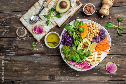 Healthy vegetarian buddha bowl salad with halloumi cheese, avocado, cucumber, chickpeas, watermelon radish, potato purple sweet. ketogenic paleo diet. Clean eating, vegan food concept. top view