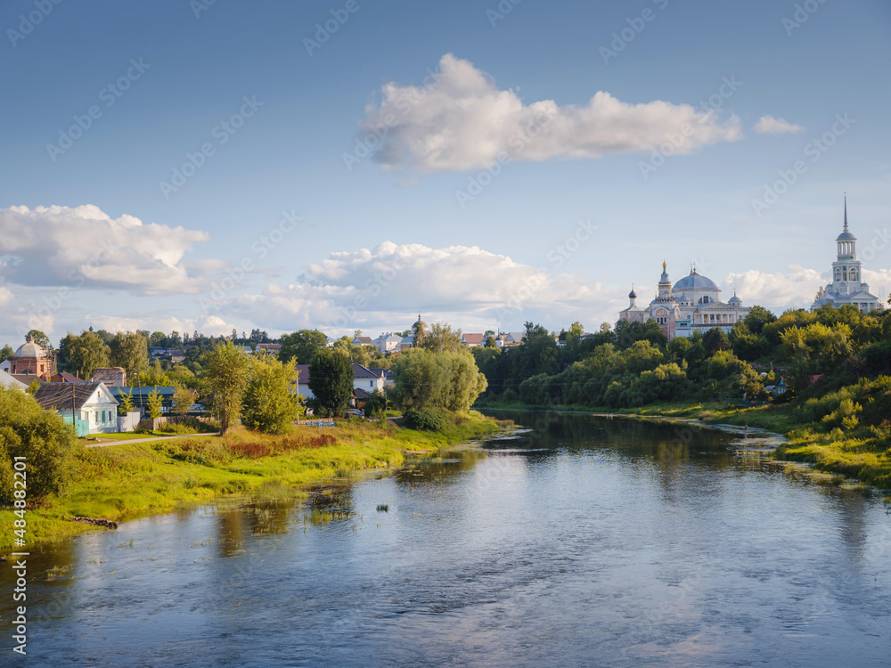 summer travel to Russia, Torzhok city, Tver region. View on old buildings at the embankment from the bridge across the Tvertsa river. Rural landscape