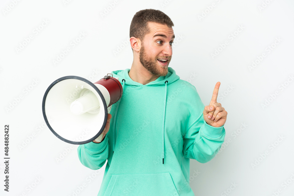 Young handsome caucasian man isolated on white background holding a megaphone and intending to realizes the solution Young handsome caucasian man isolated on white background holding a megaphone and intending to realizes the solution