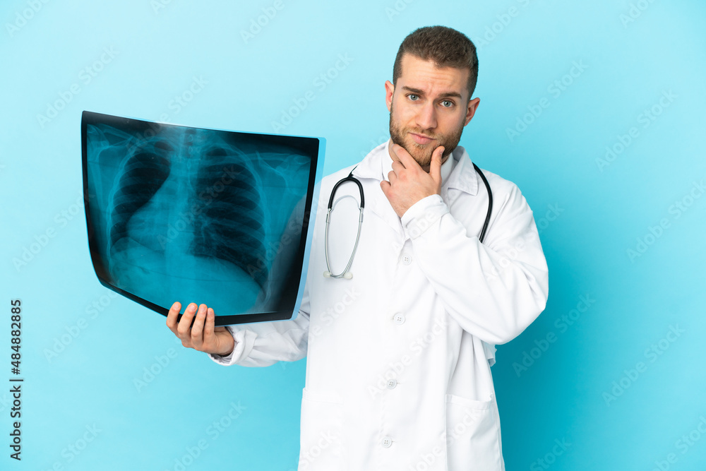 Professional traumatologist isolated on blue background thinking Professional traumatologist isolated on blue background thinking