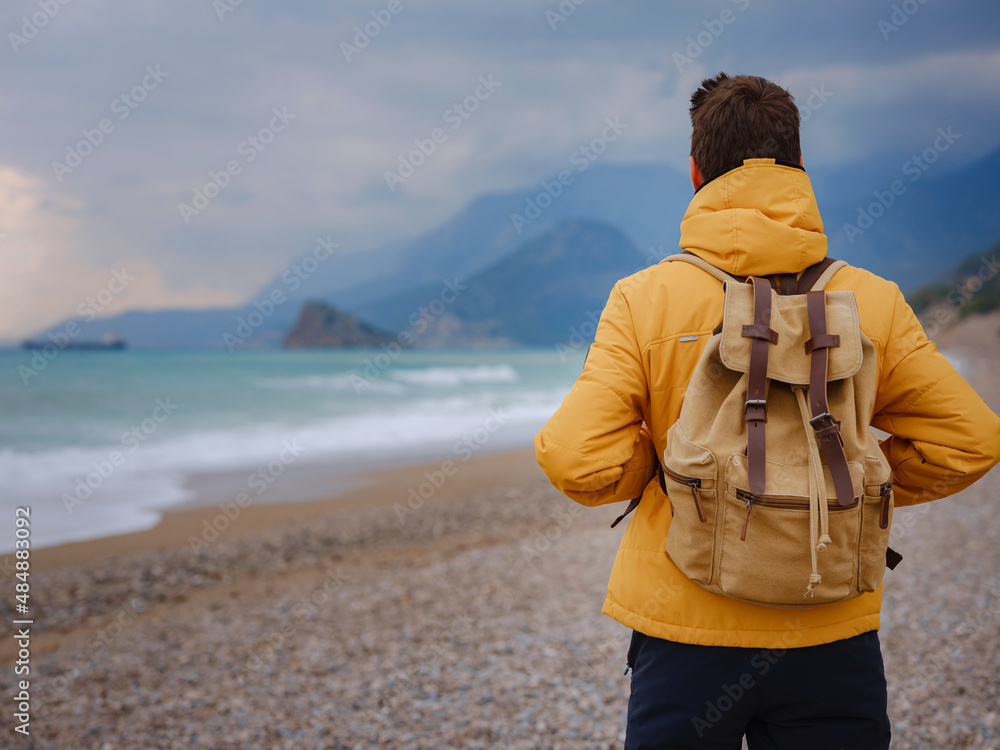 Handsome man in yellow jacket walking beach in antalya, turkey. Good looking male model looking pensive at ocean sea. Fantasy storytelling content Handsome man in yellow jacket walking beach in antalya, turkey. Good looking male model looking pensive at ocean sea. Fantasy storytelling content