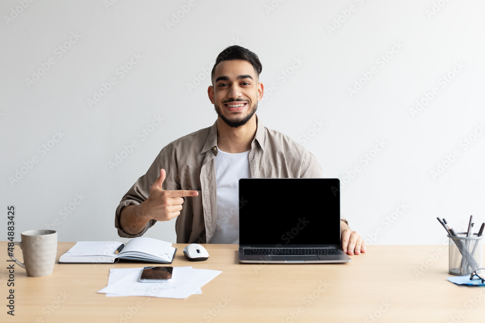 Happy Arab Guy Showing Laptop With Black Empty Screen, Mockup Happy Arab Guy Showing Laptop With Black Empty Screen, Mockup