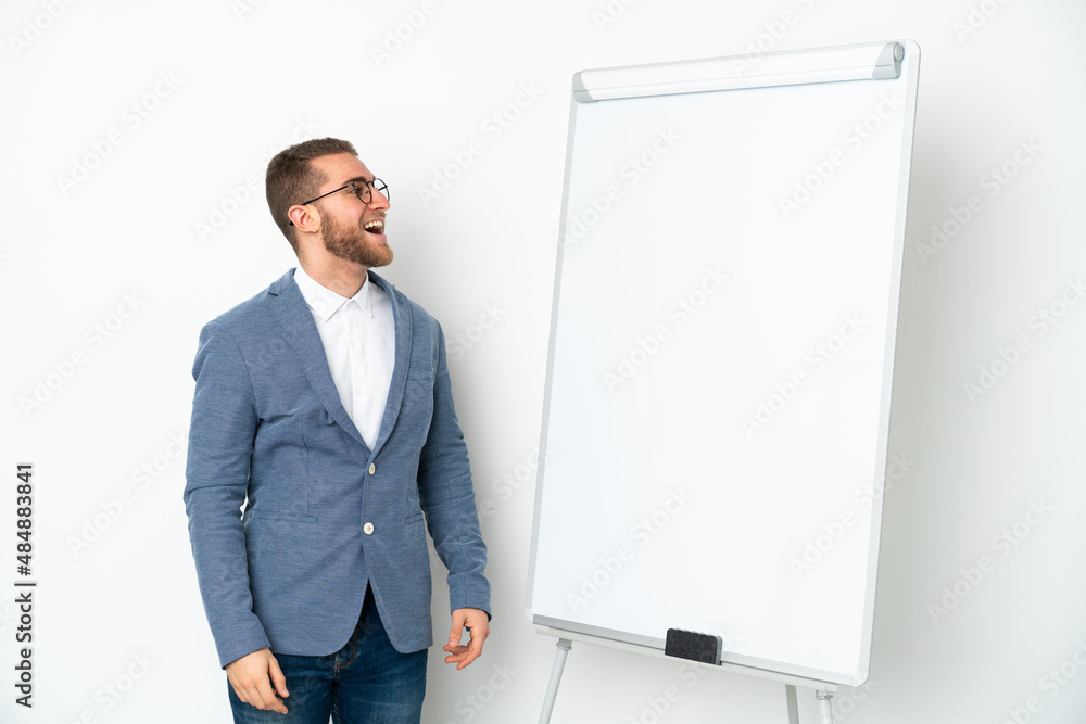 Young business woman giving a presentation on white board isolated on white background laughing in lateral position Young business woman giving a presentation on white board isolated on white background laughing in lateral position