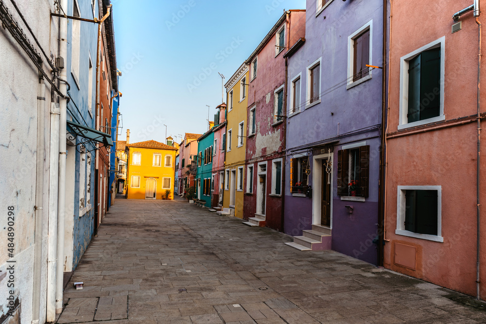 Colorful island of Burano,Venice landmark,Italy.Most colorful place in world with leaning bell tower,canals,small houses.Tranquility and calmness in Venetian Lagoon.Cobblestone street of fishing town
