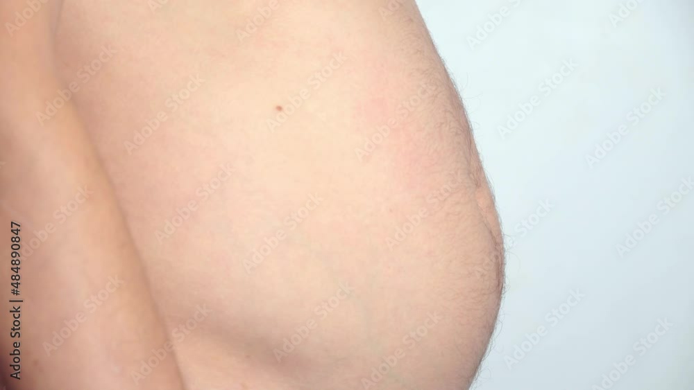 Close-up, male belly, overweight. young man with bare fat belly shakes fat folds on his stomach, obesity, health, beer belly. man himself is pumped up with muscles. Problem area of body. hormones. Close-up, male belly, overweight. young man with bare fat belly shakes fat folds on his stomach, obesity, health, beer belly. man himself is pumped up with muscles. Problem area of body. hormones.