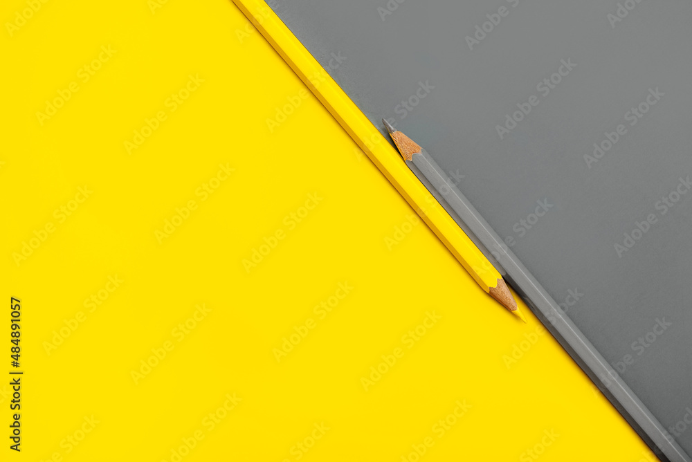 Yellow and gray pencil placed on yellow and gray paper background with copy space Yellow and gray pencil placed on yellow and gray paper background with copy space