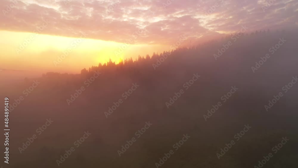 Thick fog covers mountains and forests in rays of morning light. Filmed in 4k, drone video. Thick fog covers mountains and forests in rays of morning light. Filmed in 4k, drone video.