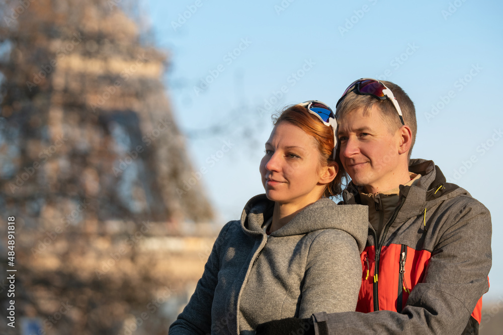 Portrait of a young couple in Paris city centre on a sunny winter day. Eiffel Tower in the background. A romantic vacation in Paris.