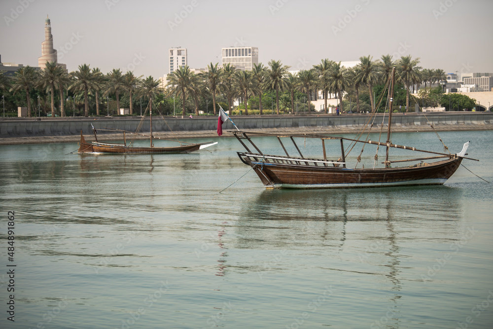Doha,Qatar- December 23,2018 : Traditional dhow boats with in the background Abdullah Bin Zaid Al Mahmoud Islamic Cultural Center.