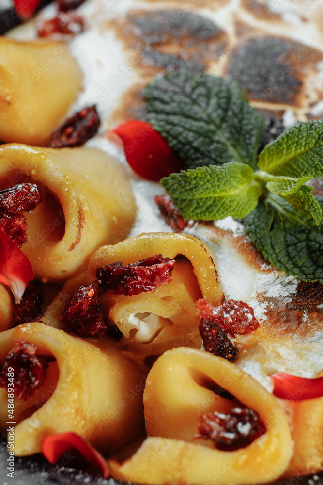 Pancakes with cheese in orange sauce served with caramelized nuts and almonds. Appetizing dish. Culinary photography, a proposal to serve a meal Pancakes with cheese in orange sauce served with caramelized nuts and almonds. Appetizing dish. Culinary photography, a proposal to serve a meal